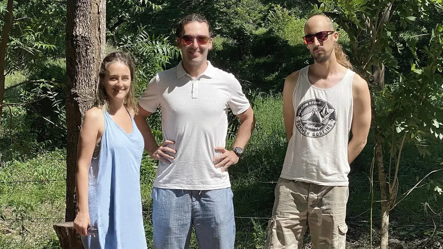 Liran standing with two friends in the forest