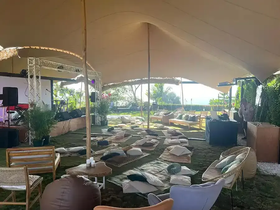 Large open tent with floor cushions and seating