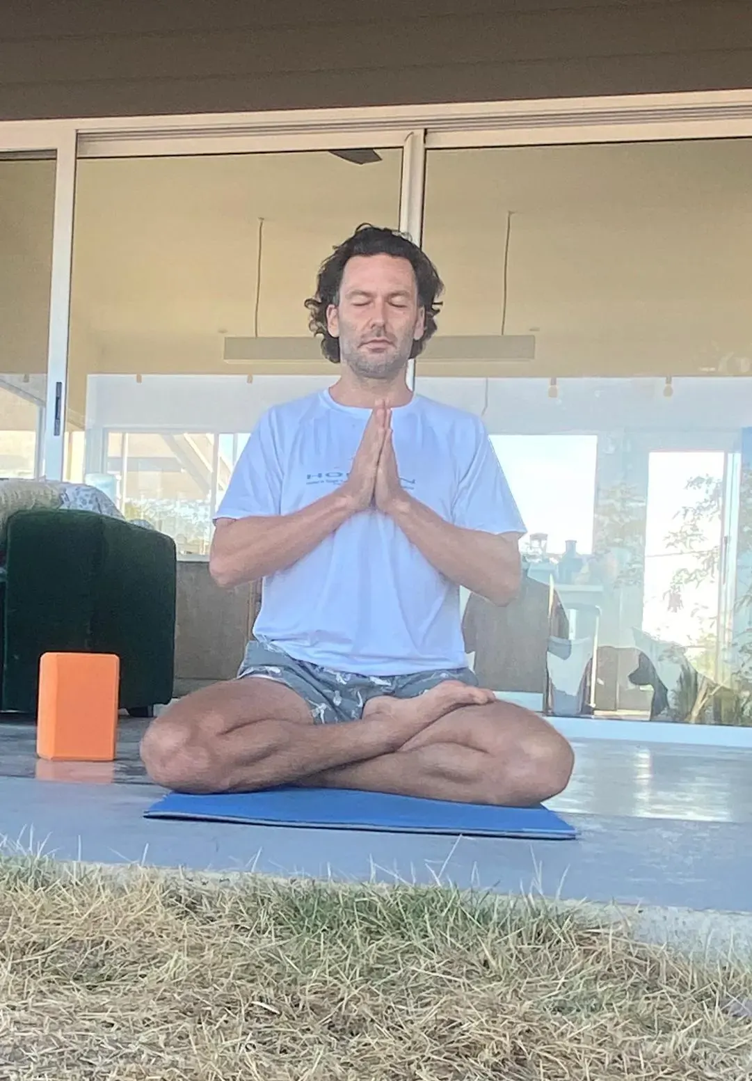 Liran meditating cross-legged on a mat
