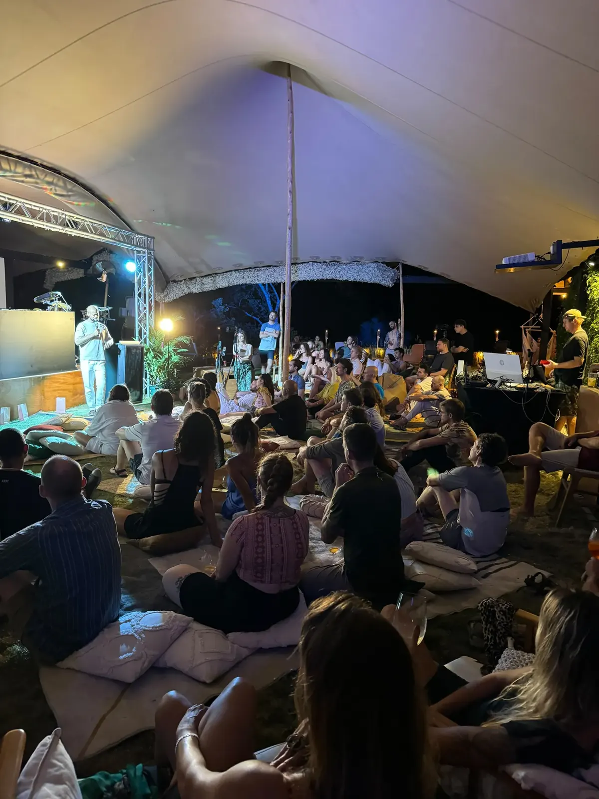Speaker on a lit stage in front of a seated crowd