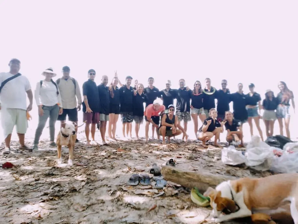 Group of volunteers on the beach with bags of collected rubbish
