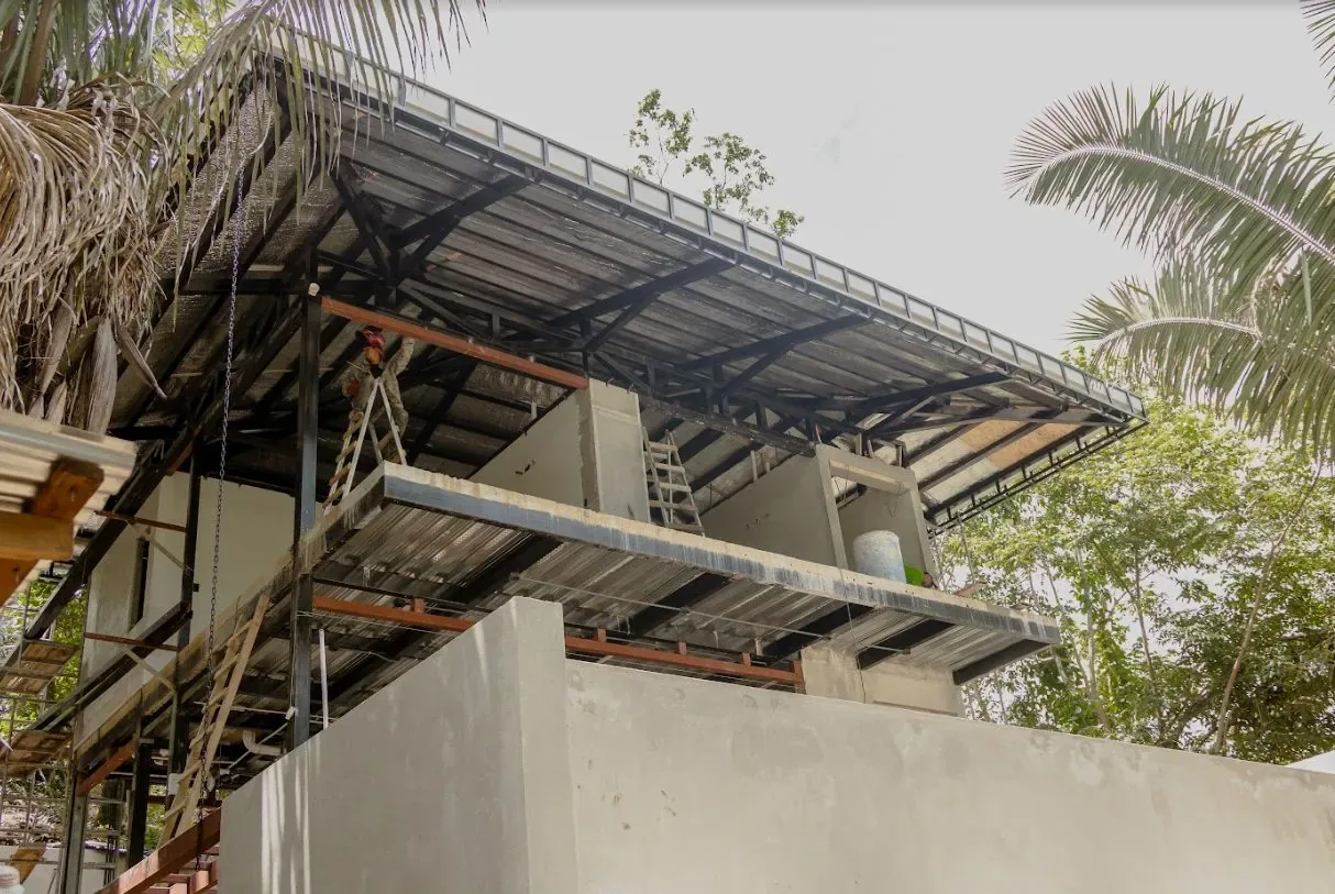 Concrete and steel villa frame among palm trees